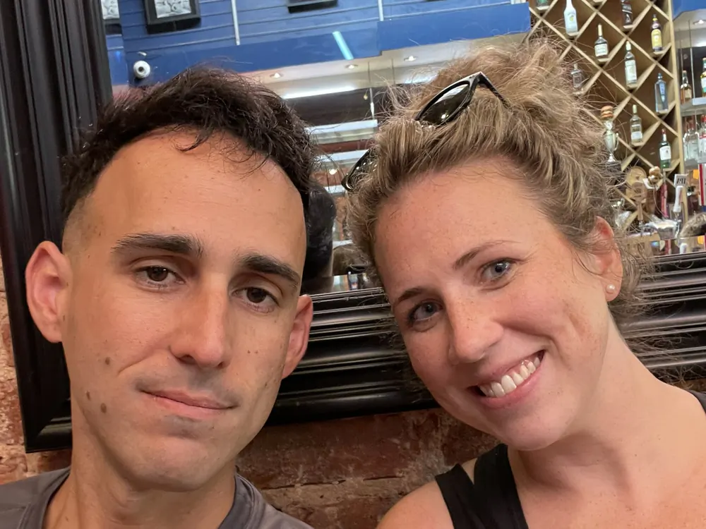 Danny and his wife in a close indoor selfie, both smiling